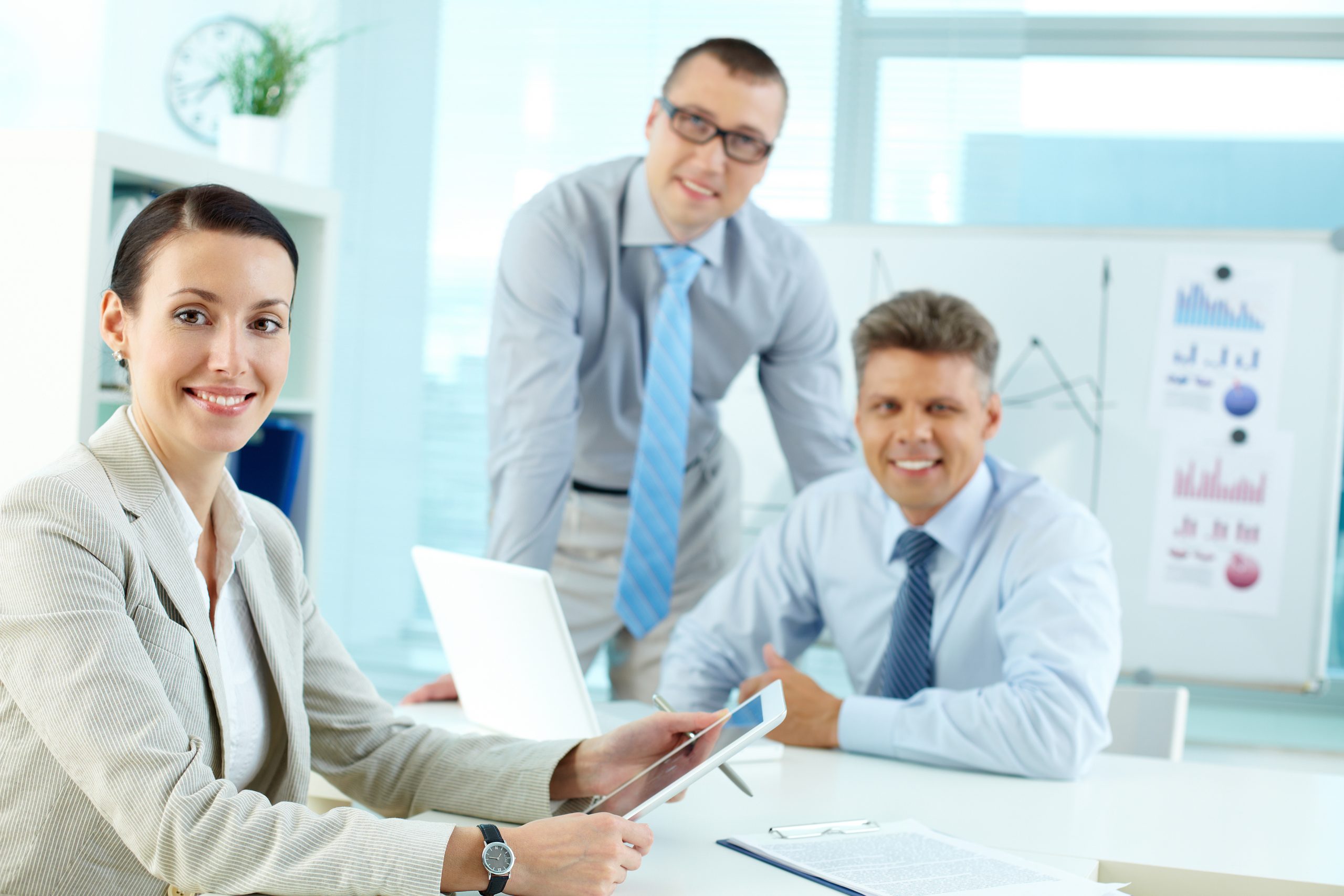 Portrait of a modern business team, pretty lady smiling in the foreground